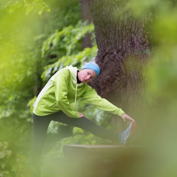 Sporty young female working out in forest.  Female runner during outdoor workout in nature. Fitness model outdoors. Weight Loss. Healthy lifestyle.