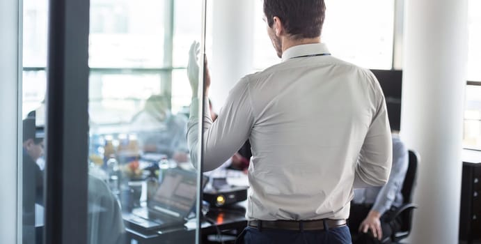 Business man making a presentation at office. Business executive delivering a presentation to his colleagues during meeting or in-house business training, explaining business plans to his employees.