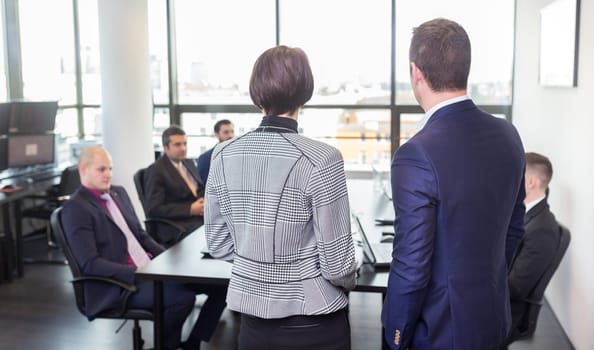 Successful team leader and business owner leading in-house business meeting, explaining business plans to his employees. Business and entrepreneurship concept.