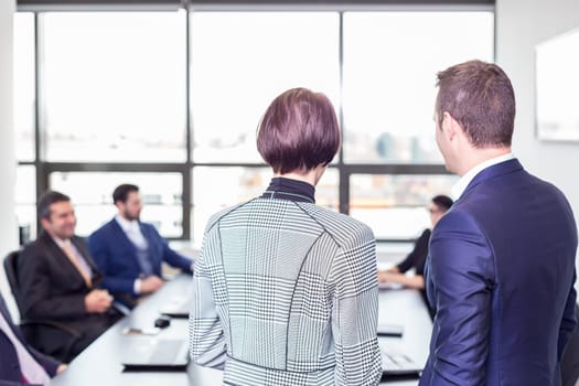 Successful team leader and business owner leading in-house business meeting, explaining business plans to his employees. Business and entrepreneurship concept.