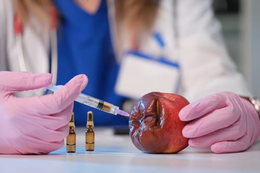 A scientist is seen injecting an apple, demonstrating advanced methods in food safety research and technology