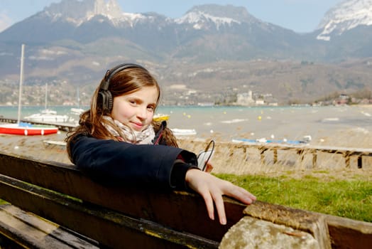 a young teenager listening to music on his phone, outdoor