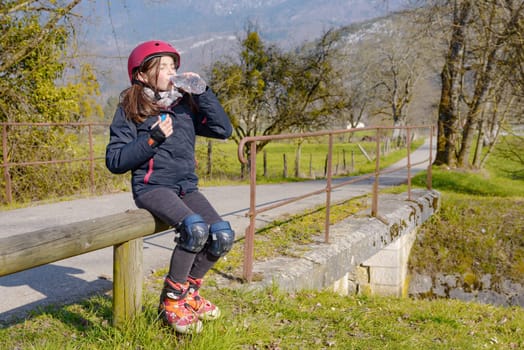 a preteen with roller skate helmet, drink a water