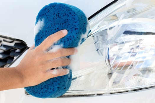 close up hand using sponge washing car