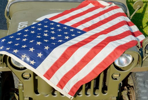 a ww2 military vehicle, jeep,with American flag
