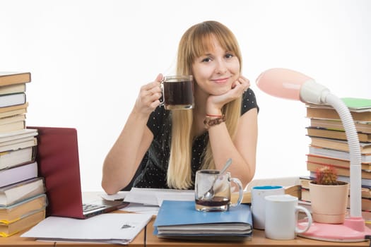 Student drinking another cup of coffee by preparing for the exam at night