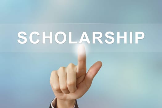 business hand pushing scholarship button on blurred background