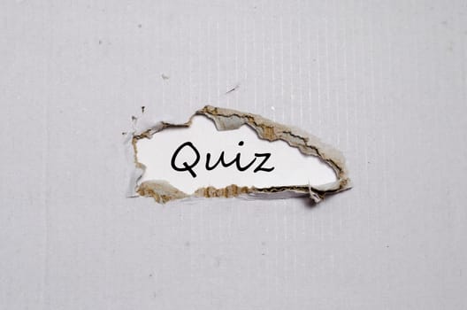 The word quiz appearing behind torn paper.