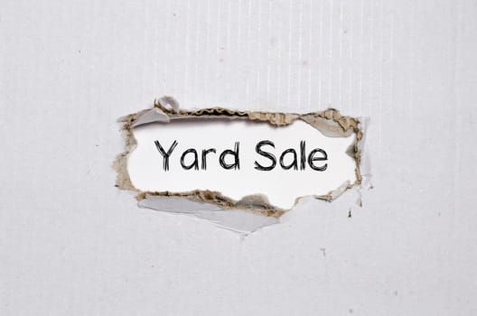 The word yard sale appearing behind torn paper.