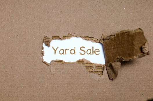 The word yard sale appearing behind torn paper.