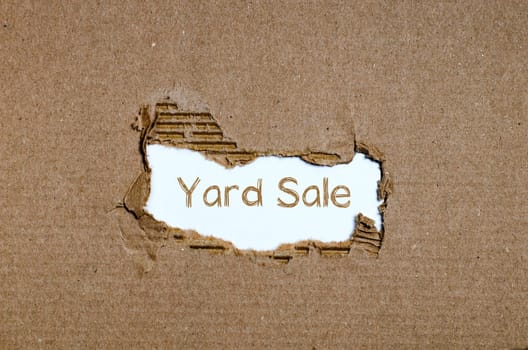 The word yard sale appearing behind torn paper.