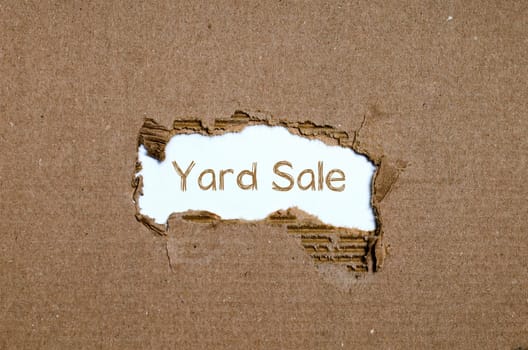 The word yard sale appearing behind torn paper.