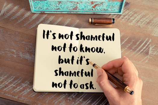 Retro effect and toned image of a woman hand writing on a notebook. Handwritten quote It&#39 s not shameful not to know, but it&#39 s shameful not to ask as inspirational concept image
