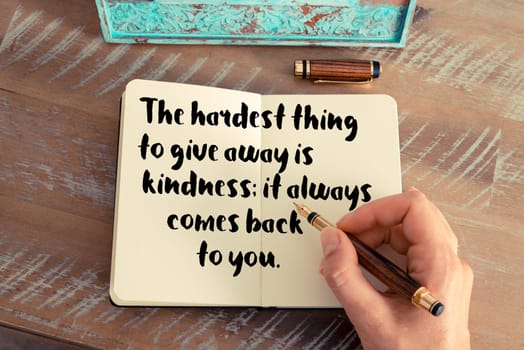 Retro effect and toned image of a woman hand writing on a notebook. Handwritten quote See with your mind, hear with your heart as inspirational concept image