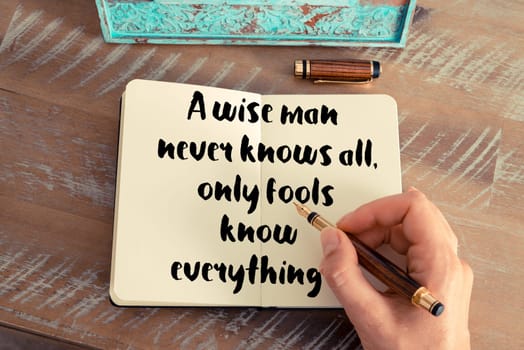 Retro effect and toned image of a woman hand writing on a notebook. Handwritten quote See with your mind, hear with your heart as inspirational concept image
