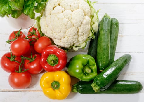 an assortment of fresh vegetables on white wooden table