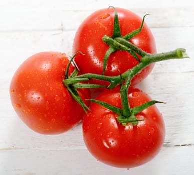 three tomatoes on a white wooden table