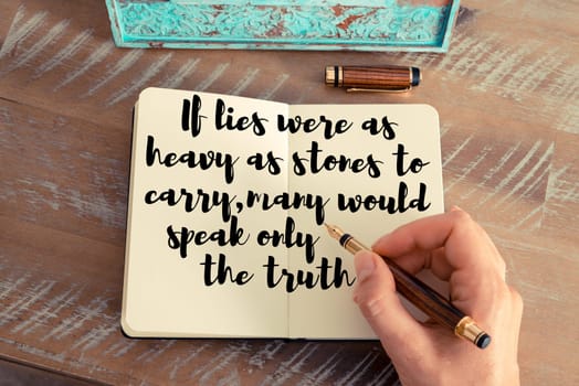 Retro effect and toned image of a woman hand writing on a notebook. Handwritten quote If lies were as heavy as stones to carry, many would speak only the truth as inspirational concept image