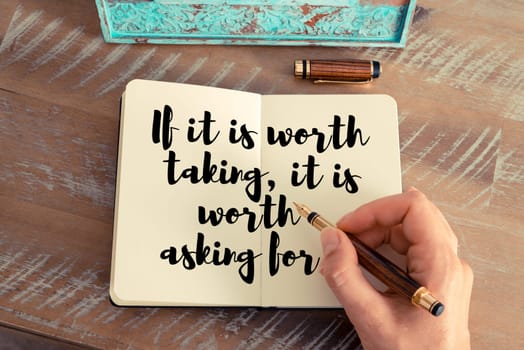Retro effect and toned image of a woman hand writing on a notebook. Handwritten quote If it is worth taking, it is worth asking for as inspirational concept image