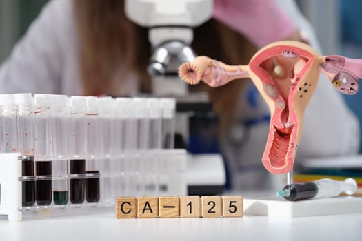 The laboratory includes a microscope, test tubes, and an educational model focusing on CA125 and womens health