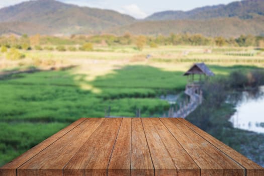 Perspective top wooden with green field blurred background, stock photo