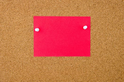 Blank red paper note pinned on cork board with white thumbtacks, copy space available