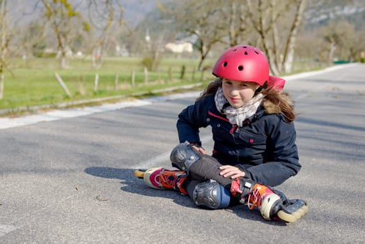 young attractive teenage skater grimacing in pain after taking a fall