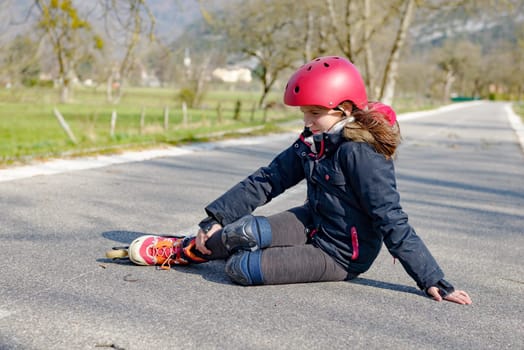 young attractive teenage skater grimacing in pain after taking a fall