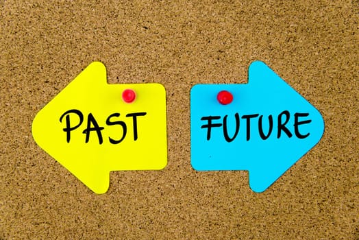 Blank yellow and blue paper notes in shape of opposite arrows pinned on cork board with thumbtacks, copy space available