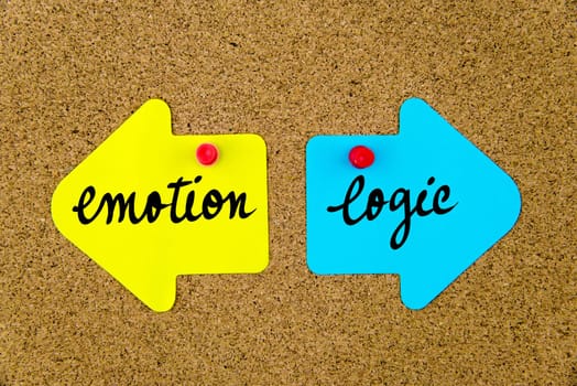 Blank yellow and blue paper notes in shape of opposite arrows pinned on cork board with thumbtacks, copy space available
