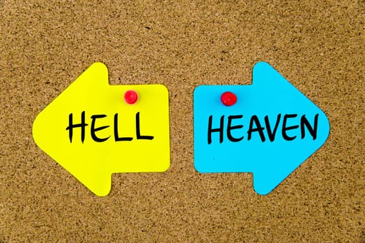Blank yellow and blue paper notes in shape of opposite arrows pinned on cork board with thumbtacks, copy space available