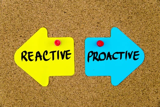 Blank yellow and blue paper notes in shape of opposite arrows pinned on cork board with thumbtacks, copy space available