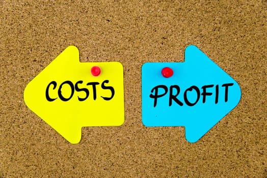 Blank yellow and blue paper notes in shape of opposite arrows pinned on cork board with thumbtacks, copy space available
