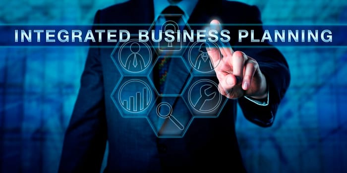 Executive pressing INTEGRATED BUSINESS PLANNING on an interactive virtual touch screen interface. Business performance function metaphor and corporate concept for strategic planning and management.