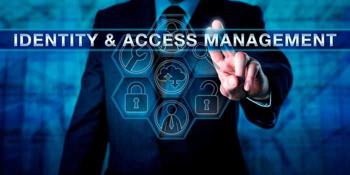 Manager pushing IDENTITY & ACCESS MANAGEMENT on a virtual interactive touch screen. Business metaphor and computer security procedure concept for technology enabling access to authenticated users.