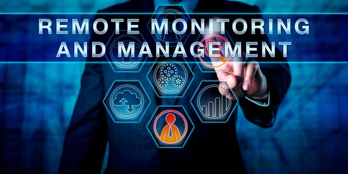 Male corporate business administrator in blue is pushing REMOTE MONITORING AND MANAGEMENT on an interactive control screen. Remote administration software concept. Industry term abbreviated as RMM.