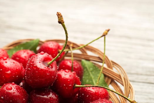 Basket of fresh cherries with water drops macro background.