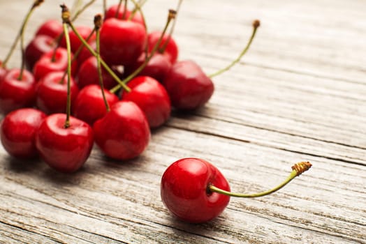 Fresh cherries on wooden table close up.