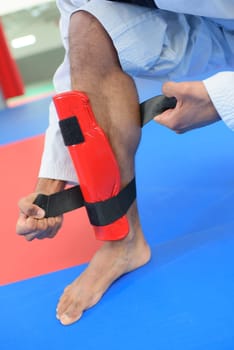 Martial artist attaching leg guard
