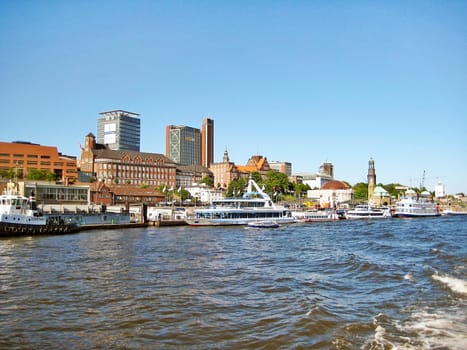 Hamburg, Germany - May 22, 2008: Hamburg harbor "Hamburger Hafen"" - ships / boats along the riverside - old brick building in the background."