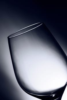 Close-up of an empty wine glass in front of an illuminated studio background