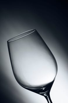 Close-up of an empty wine glass in front of an illuminated studio background