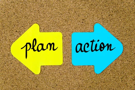 Message Plan versus Action on yellow and blue paper notes as opposite arrows pinned on cork board with thumbtacks. Choice conceptual image