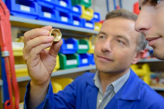 Man showing copper nut to apprentice