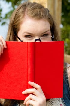 Young woman with book in nature