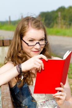Young woman with book in nature