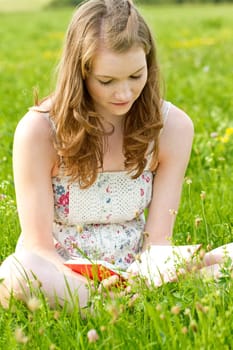 Girl with book on a meadow