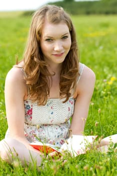 Girl with book on a meadow