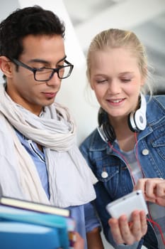 Friends in school listening to music with smartphone