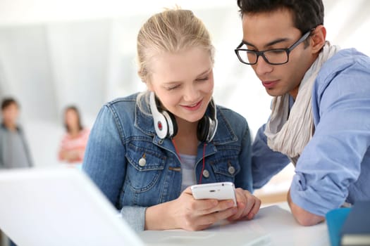 Young people in college lounge using smartphone